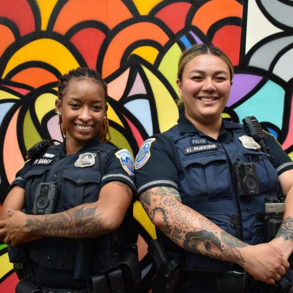Officers in front of a mural